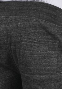Pantalones jogger de color gris oscuro, fabricados con un tejido de punto texturizado, que cuentan con una cintura acanalada y un bolsillo trasero.