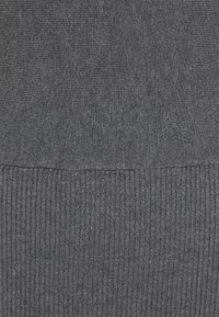 Gestrickter grauer Pulloverstoff mit glatter, texturierten Oberfläche und geripptem Saum. Die Farbe ist ein einheitliches Dunkelgrau mit leichten Sprenkeln.