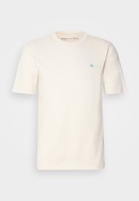 Cremfarbendes Baumwoll-T-Shirt mit kurzen Ärmeln, Rundhals und einem kleinen blauen Emblem auf der linken Brust. Weicher Stoff und lockere Passform.