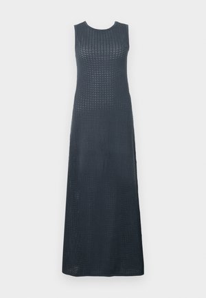 Gara, bez piedurknēm, kleita tumši zili. Iespējojusi teksturētu adījuma rakstu, noapaļotu kakla izgriezumu un taisnu, plūstošu siluetu.