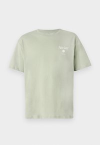 Lys grøn bomulds t-shirt med korte ærmer, prydet med teksten "Palm Coast" og en solgrafik i hvid på forsiden.