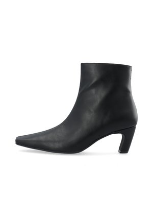 Botín negro de cuero hasta el tobillo con punta afilada y tacón de altura media. Textura suave, diseño elegante y acentos minimalistas en el tacón.