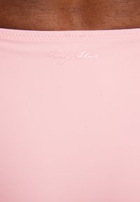 Różowa tkanina o gładkiej fakturze, z subtelnym wytłoczonym logo "Big Star" na górze. Prosty design, bez dodatkowych wzorów ani akcentów.