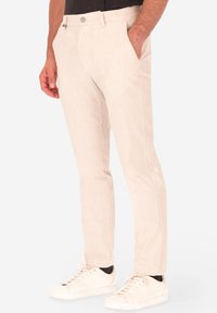 Pantaloni a righe beige realizzati in un tessuto leggero, con una vestibilità sartoriale, tasche laterali e chiusura con bottone in vita.