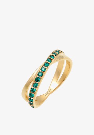 Auksinės spalvos žiedas su įvyniotais žiedais, papuoštas žalių brangakmenių eile. Lygus paviršius su blizgiu apdaila. Pažymėtas 925.