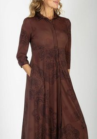 Brązowa sukienka z kołnierzykiem, z rękawami ¾ i misternymi ciemnymi wzorami paisley. Posiada dwie boczne kieszenie i zwiewny krój.