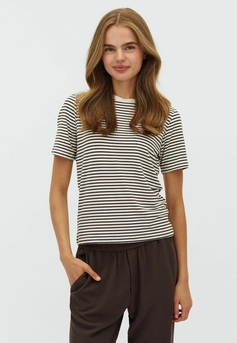Striped t-shirt in cream and brown, short sleeves, round neck, fitted design, with a smooth texture. Model poses with one hand in pocket.