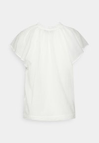 Haut blanc à manches courtes en tissu léger, avec un col à volants et une silhouette fluide avec un ourlet droit.