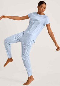 Lichtblauwe loungewear-set gemaakt van zachte stof, met een relax-fit top met korte mouwen en aangesloten broek met zijzakken.