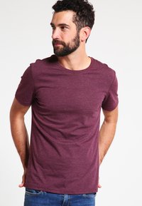 Bordeaux rotes T-Shirt mit kurzen Ärmeln und Rundhals, aus weichem Stoff, mit schmalem Schnitt und glatter Textur. Einfach und uni ohne Muster.