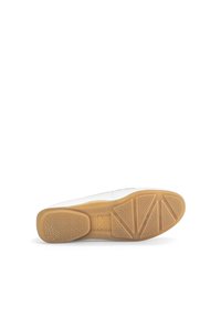Chaussure blanche avec une tige en cuir lisse et une semelle en caoutchouc présentant une texture en nid d'abeille, entourée d'un dessous de couleur beige avec des motifs de crampons distincts.