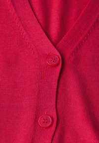 Cardigan tricoté rouge avec un col en V et deux boutons rouges. Le tissu est lisse avec des détails de couture subtils le long des bords.