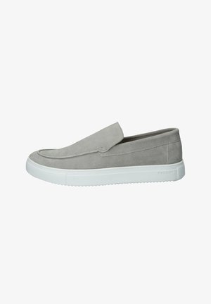 Chaussures en daim gris à enfiler avec un bout arrondi et une semelle en caoutchouc blanche. Texture lisse, couture minimale et sans accents métalliques visibles.