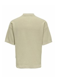 Sweter polo w jasnym beżowym kolorze, krótki rękaw, kołnierz, luźny krój, teksturowany materiał, brak widocznych wzorów, gładki widok z tyłu.
