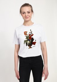 Bílé tričko s barevným květinovým motivem v ozdobné váze, převážně červené a modré květy s propracovanými detaily.