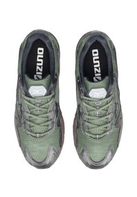 Sneakers sportivi verdi con parte superiore in mesh, punta arrotondata e accenti grigi. Presentano una texture di tessuto e chiusura con lacci. Logo visibile sulla soletta.