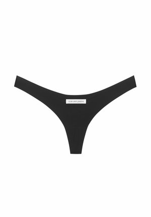 Černé tangové spodní prádlo vyrobené z hladkého materiálu, s minimalistickým designem a štítkem s nápisem "GOD SAVE QUEENS" vyšitou na přední straně.