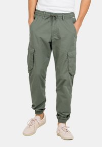 Pantalones cargo en verde oliva, fabricados con tejido ligero, presentan una cinturilla elástica con cordón ajustable y varios bolsillos laterales.