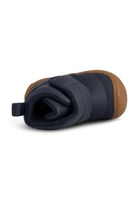 Bota azul marino con parte superior acolchada, correa de velcro ajustable y suela de goma color marrón. Cuenta con un tirador reforzado en el talón para facilitar su uso.