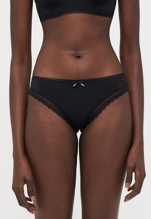 Culotte noire avec dentelle, dotée d'un petit nœud sur le devant. Texture lisse et coupe régulière.