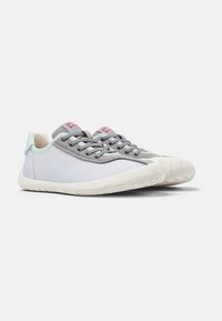 Sneaker leggere con tomaia in tessuto grigio, suola in gomma bianca, dettagli in verde menta e texture lungo la suola e i fori per i lacci.