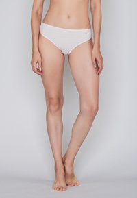 White cotton brief with a wave pattern, low-rise design, and soft texture; featuring a smooth waistband and no visible hardware.