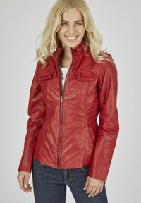 Rote Lederjacke mit taillierter Passform, zwei Brusttaschen und Reißverschluss. Glatte Textur mit sichtbaren Nähdetails. Getragen über einem weißen Oberteil.