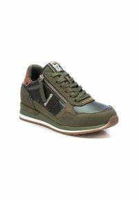 Zapatilla deportiva verde que combina diferentes materiales, incluyendo cuero y ante. Detalle de cremallera en el lateral, parte trasera texturizada y suela blanca.