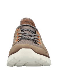 Chaussure de sport beige avec un dessus en tissu texturé, des lacets orange contrastants et une semelle en caoutchouc blanc avec un motif de semelle.