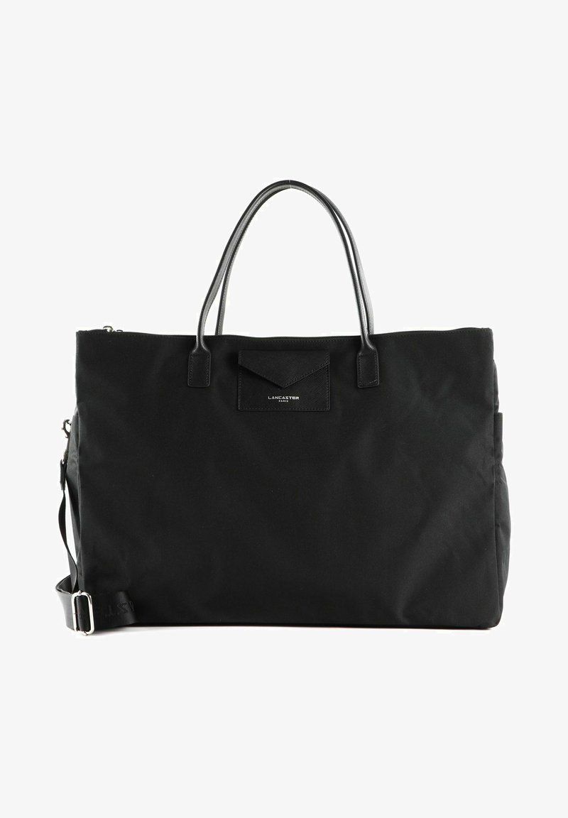 Sac fourre-tout en tissu noir avec des poignées en cuir doubles, une fermeture zippée et une poche avant. Présente une texture délicate et des détails matériels minimalistes.