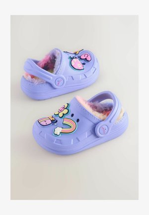 Violeta koka sandales ar pūkainu oderi, kuru rotāšanai izmantoti krāsaini plastmasas dekori, piemēram, ziedi, sirdis un varavīksne, ar aizmugures siksniņu.