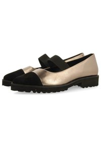 Zapatos metálicos en oro y negro con punta redonda, que presentan una puntera de ante negro y una tira elástica negra en el empeine. Suela texturizada.