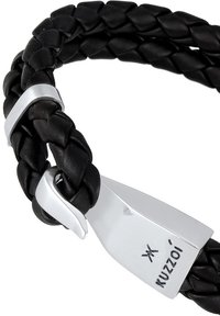 Svart flätat läderarmband med ett silvrigt spänne med ingraverad logotyp. Texturerad yta med släta detaljer.