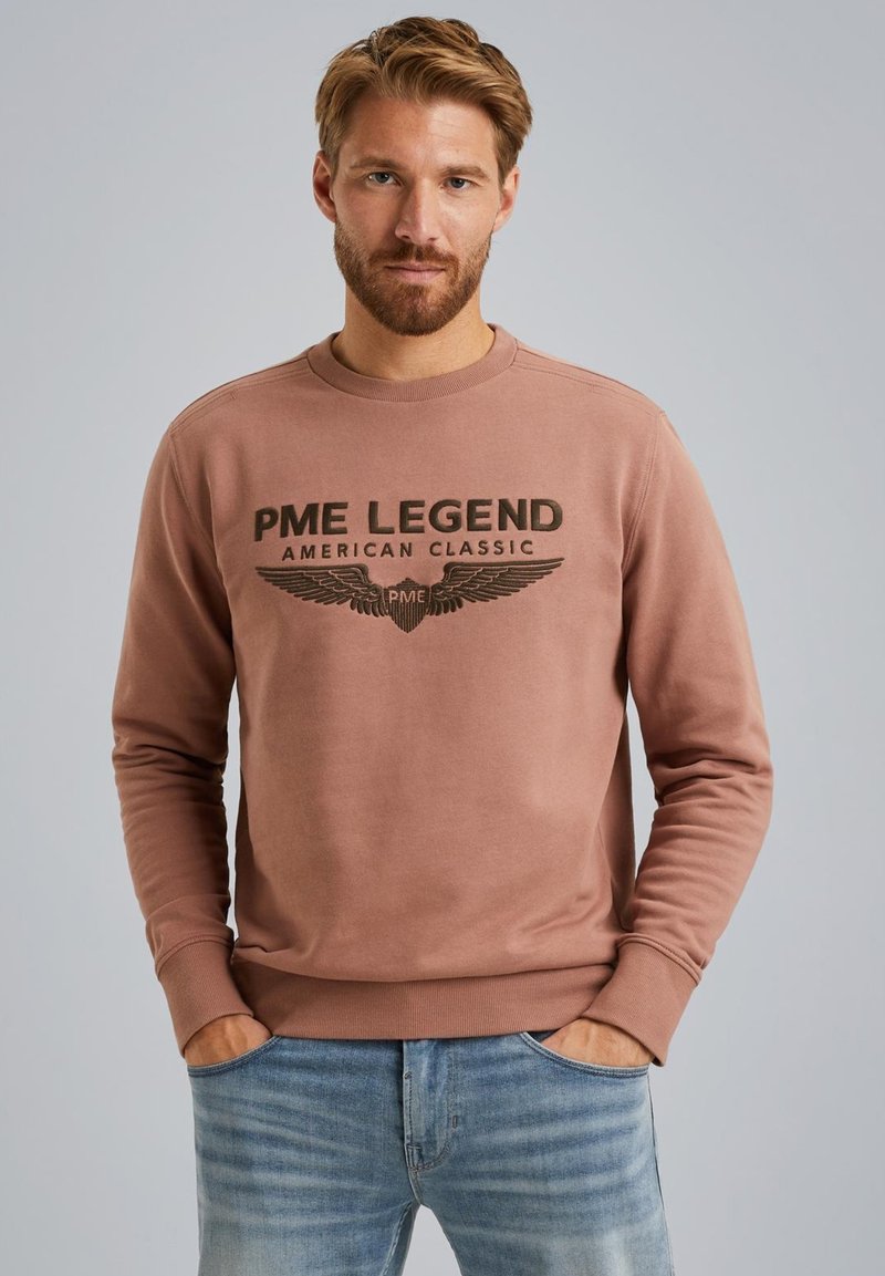 Bruine sweatshirt met ronde hals, voorzien van een opdruk met "PME LEGEND AMERICAN CLASSIC" en vleugelgraphics.