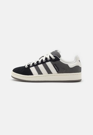 Low-top Adidas Campus sneaker in black and white with three white stripes, lace-up closure, and cushioned sole on plain white background.