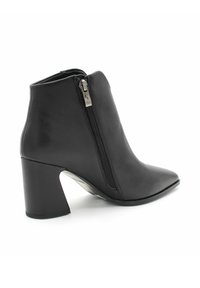 Czarny skórzany botek za kostkę z ostrym noskiem, bocznym zamkiem i grubym obcasem. Gładka struktura z czystymi liniami i minimalnymi detalami.