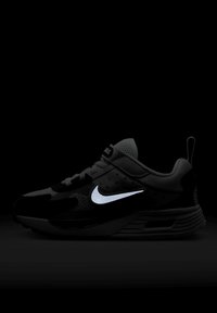 Sapatilha atlética preta com parte superior texturizada, logo do swoosh refletivo, detalhes em malha e sola acolchoada. Possui uma alça na parte de trás.