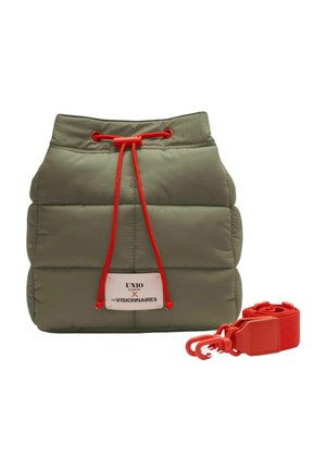 Pochette matelassée vert olive avec cordon de serrage rouge et bandoulière détachable rouge, équipée d'une étiquette blanche avec texte noir et rouge.