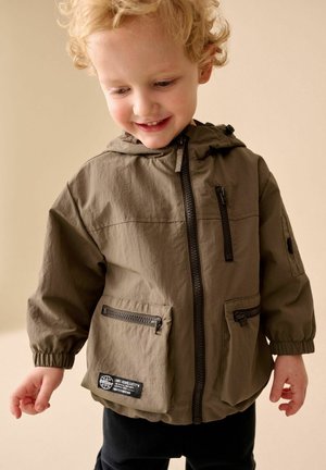 Olivgrüne, leichte Jacke mit Kapuze, Reißverschluss, zwei Vordertaschen und elastischen Bündchen. Verfügt über ein Markenzeichen an der Tasche.