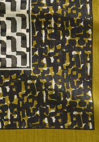 Tissu à motifs noirs, vert olive et blanc avec des formes abstraites ; texture lisse, bordée d'un bord uni vert olive.