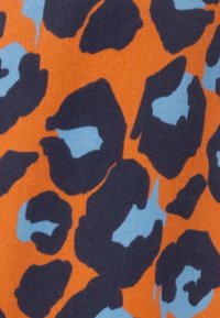 Tessuto intrecciato con uno sfondo arancione audace e un motivo a macchie di leopardo blu scuro e blu chiaro. Superficie texture, contrasto vivace.