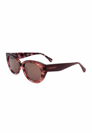 Occhiali da sole a forma di occhio di gatto in tartaruga con lenti scure e aste sottili, con logo "Ted Baker" sul lato.