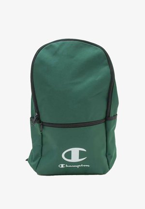 Zaino verde scuro con cerniere nere e logo Champion bianco sulla tasca frontale inferiore su sfondo bianco.