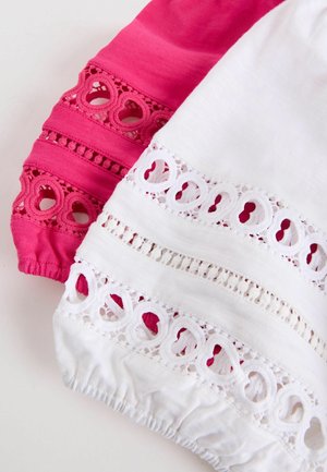 Manșete din material alb și roz, cu modele de dantelă tăiate în formă de inimă și cu mansete elastice strânse.