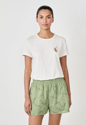 Witte katoenen t-shirt met opgerolde mouwen en geborduurde "Zomer"-ontwerp. Groene shorts met kant uitsparingen en een elastische tailleband.