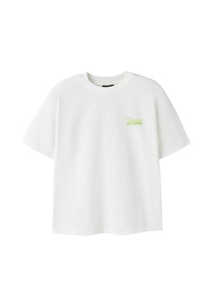 T-shirt blanc à manches courtes avec col rond et petit texte vert "Dreamstate California" sur le haut gauche de la poitrine.