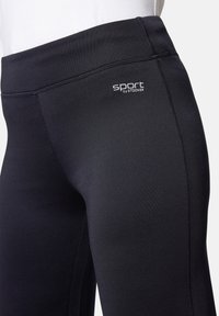 Schwarze Sportleggings mit glatter Oberfläche, einem breiten Taillenbund und einem Logo mit der Aufschrift "sport by STOOKER" auf der Vorderseite.