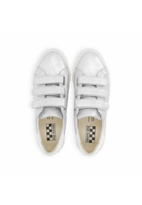 White leather sneakers with three Velcro straps, rounded toe, and a textured surface. Inner label with contrasting checkerboard design.