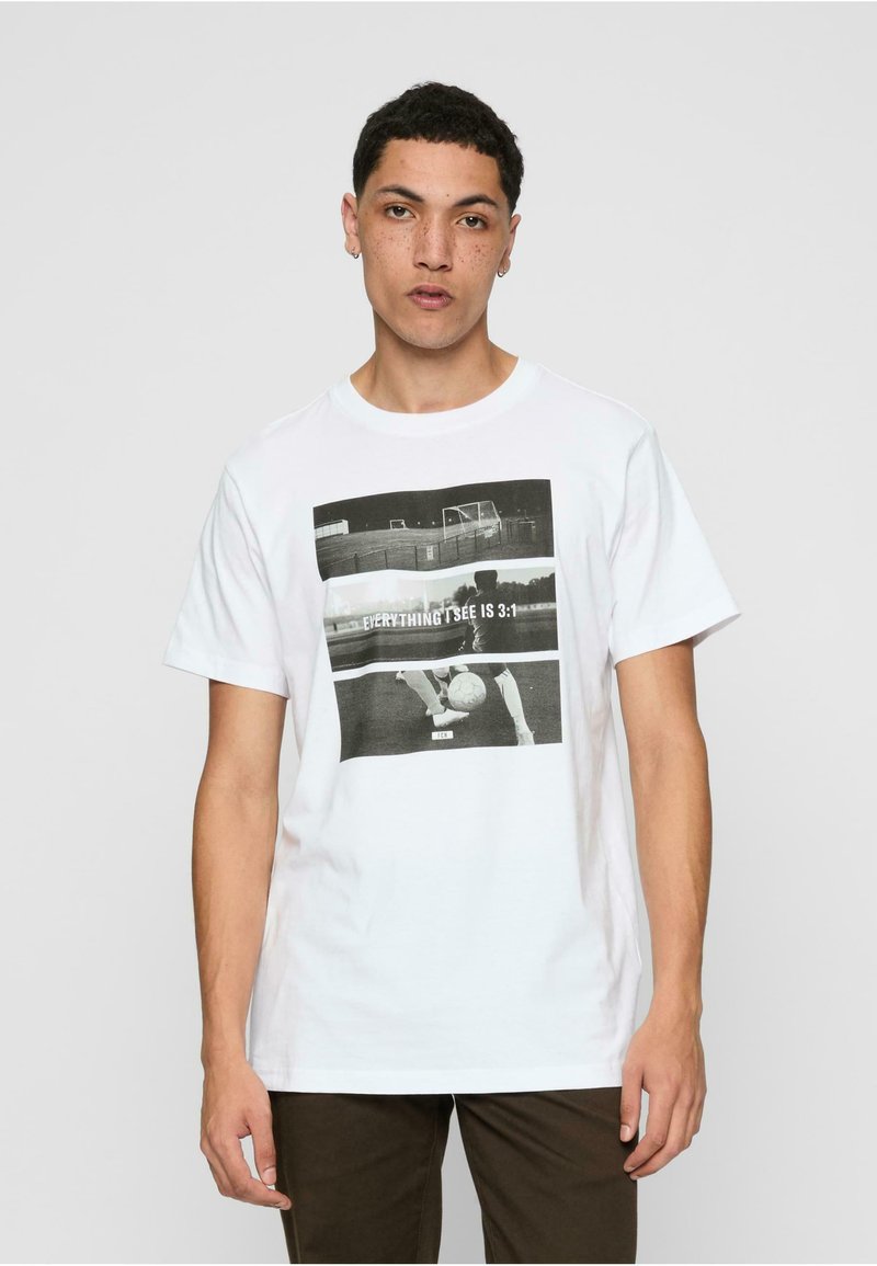 Camiseta de algodón blanca con una impresión gráfica en blanco y negro de una escena de fútbol y el texto "TODO LO QUE VEO ES 3:1". Mangas cortas, cuello redondo.