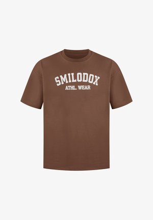 T-shirt en coton marron avec le texte blanc "SMILODOX ATHL. WEAR" dans un design en arc. Col rond et manches courtes. Texture lisse.